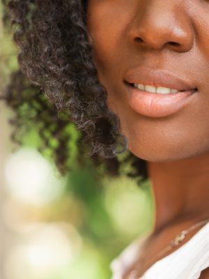 Cropped view of smiling young attractive African American woman outdoors