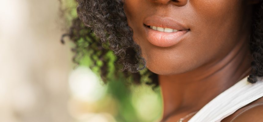 Cropped view of smiling young attractive African American woman outdoors